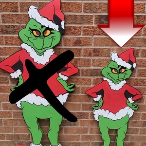 Peut inclure: Deux figurines vertes du Grinch portant des bonnets de Père Noël et des costumes rouges avec des bordures de fourrure blanche. Le plus grand Grinch est debout, les mains sur les hanches, tandis que le plus petit Grinch est debout, les mains sur les hanches. Les deux figurines sont en bois et peintes de couleurs vives.