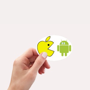 May include: A yellow Pac-Man shaped apple logo is eating a green Android robot logo. The logos are on a white oval sticker.