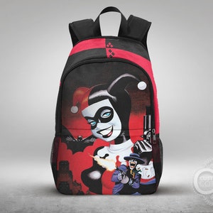 May include: A black backpack with a red and black checkered pattern. The front of the backpack features a colorful graphic of Harley Quinn holding a gun. The graphic also includes a cityscape and a figure of the Joker.