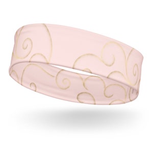 May include: A pink headband with a gold swirl pattern.