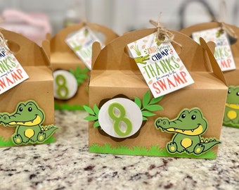 May include: Brown favor boxes with green alligator designs and a tag that says "Snid Snap Chomp! Thanks for coming to the Swamp".