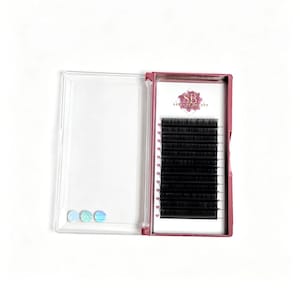 May include: A rectangular plastic case with a clear lid and a dark pink base containing twelve rows of black individual eyelash extensions. The interior features the logo SB Salluxe Beauty and three small iridescent circular stickers.