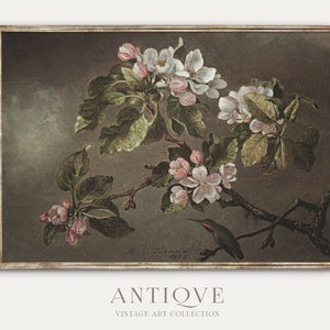 May include: A vintage painting of a hummingbird perched on a branch of a flowering apple tree. The painting is framed in a dark brown frame with a gold trim. The background is a muted brown color. The painting is signed "J.F. Kenna 1925".