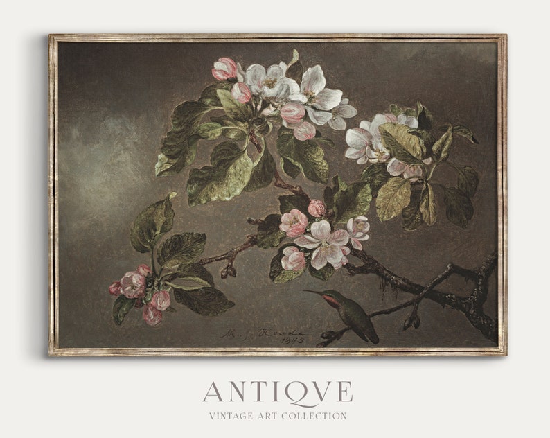 May include: A vintage painting of a hummingbird perched on a branch of a flowering apple tree. The painting is framed in a dark brown frame with a gold trim. The background is a muted brown color. The painting is signed "J.F. Kenna 1925".