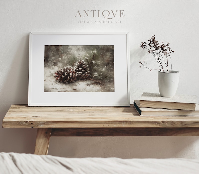 May include: Two brown pine cones on a snowy forest floor with a blurred background of green trees and white snow. The pine cones are in focus and the background is out of focus.