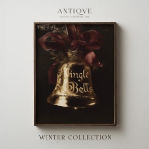 Könnte beinhalten: Ein gerahmter Kunstdruck mit einer goldenen Glocke, die mit einem dunkelroten Band vor schwarzem Hintergrund gebunden ist. Die Glocke trägt die goldene Aufschrift Jingle Bells. Der Druck ist mit ANTIQVE VINTAGE AESTHETIC ART und WINTER COLLECTION beschriftet.
