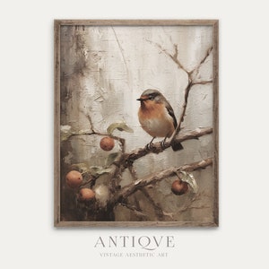 Puede incluir: Una pintura enmarcada de un pequeño pájaro posado en una rama con manzanas rojas. El fondo es un diseño abstracto en tonos apagados de marrón y blanco. La pintura tiene un aspecto rústico y vintage.