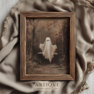 May include: A framed vintage print depicting a white ghost on a swing in a woodland scene. The artwork has a sepia tone, with the word "ANTIQVE" and "VINTAGE AESTHETIC ART" printed at the bottom. The frame is made of wood.