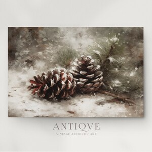 May include: Two pine cones covered in snow, resting on a snowy surface with a pine branch in the background. The pine cones are brown with a reddish hue and have a textured surface.
