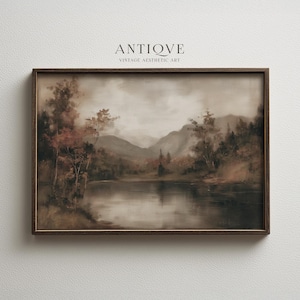 May include: A framed landscape painting with a vintage aesthetic. The artwork depicts a serene lake scene with mountains in the background. The color palette is muted, featuring browns, greens, and grays. The frame is dark brown, and the text "ANTIOVE VINTAGE AESTHETIC ART" is at the top.
