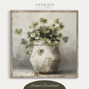 Może przedstawiać: Malowanie przedstawiające biały ceramiczny wazon z bukietem zielonych liści. Wazon ma rustykalny, postarzany wygląd i stoi na jasnoszarym tle. Tło jest jasnoszare z subtelną fakturą.