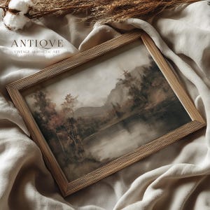 May include: A framed vintage landscape painting with a muted color palette. The artwork depicts a serene lake scene with trees and mountains. The frame is made of light-colored wood. The text "ANTIQVE VINTAGE AESTHETIC ART" is visible in the upper left corner.