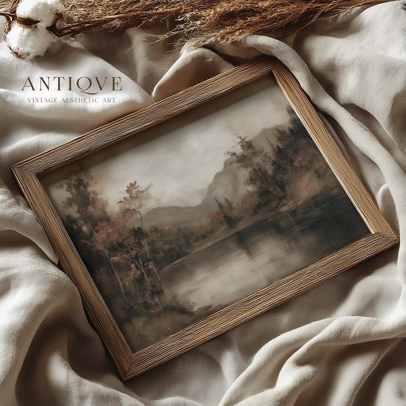 May include: A framed vintage landscape painting with a muted color palette. The artwork depicts a serene lake scene with trees and mountains. The frame is made of light-colored wood. The text "ANTIQVE VINTAGE AESTHETIC ART" is visible in the upper left corner.
