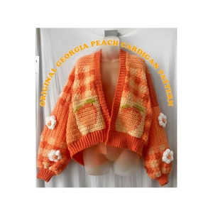 Puede incluir: Un cárdigan de ganchillo en tonos naranja y blanco con un diseño de melocotón. El cárdigan tiene cuello en V y mangas largas con detalles de flores. El texto "ORIGINAL GEORGIA PEACH CARDIGAN PATTERN" está escrito alrededor de la imagen.