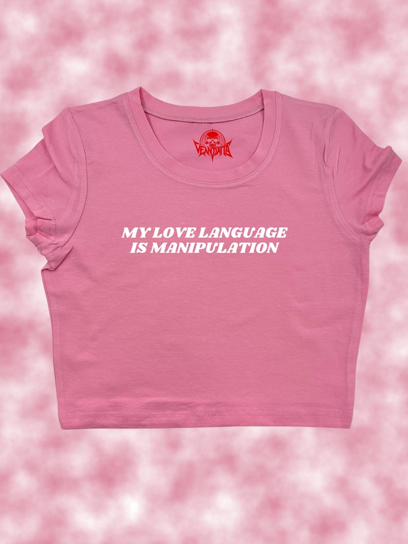 May include: Pink cropped t-shirt with the text "MY LOVE LANGUAGE IS MANIPULATION" in white letters.