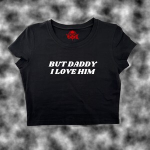 May include: Black cropped t-shirt with white text that reads "BUT DADDY I LOVE HIM".