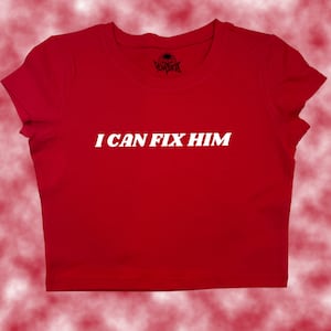 May include: Red cropped t-shirt with white text that reads "I CAN FIX HIM".