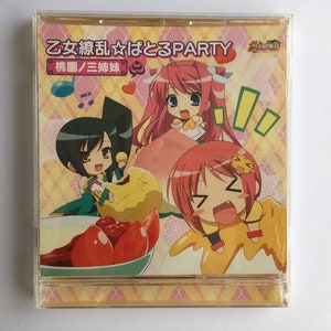 May include: A pink and yellow CD case with a cartoon image of three girls. The text on the case reads "乙女 戀 乱☆はとるPARTY 妖精國/三姉妹".