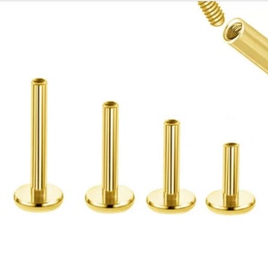 Może przedstawiać: Cztery złote kolczyki do ciała z płaskimi zapięciami. Kolczyki mają różne długości, od krótkich do długich.