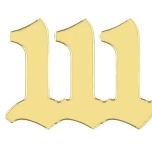 May include: A gold-colored numeral 111 in an old English font. The numbers are stylized with a decorative, curved base and a slightly pointed top. The image is set against a plain white background.