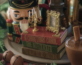 Peut inclure: Une composition de Noël avec un récipient en forme de casse-noisette, une pile de livres sur le thème de Noël, un petit cadre doré et un chandelier doré avec des bougies allumées. L'ensemble est posé sur un tissu à carreaux.