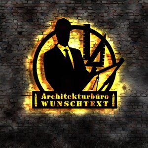 May include: A black silhouette of an architect with a hard hat and tools, inside a circle with a yellow glow. The text "Architekturburo WUNSCHTEXT" is below the circle.
