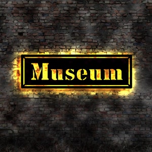 May include: A glowing yellow sign with black lettering on a brick wall reads "Museum".
