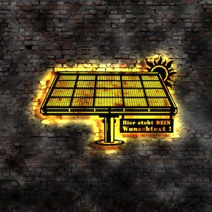 May include: A black solar panel with a yellow glow, mounted on a brick wall. The text "Hier steht DEIN Wunschtext!" is visible below the panel.