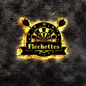 Puede incluir: Un letrero de neón en blanco y negro con un tablero de dardos y dos dardos. El letrero dice "Fléchettes" en una fuente decorativa.