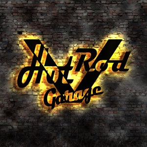 May include: A neon sign with the words "Hot Rod Garage" in black letters on a yellow background. The sign is mounted on a brick wall.