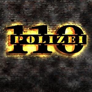 Op de afbeelding: Een bakstenen muur met een neonbord waarop "110 POLIZEI" staat in zwarte letters met een gele gloed.