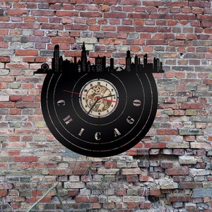 Könnte beinhalten: Schwarze Schallplattenuhr mit einer Stadt-Silhouette von Chicago und einem Zifferblatt mit Zahnrädern. Die Uhr ist an einer Backsteinwand montiert.