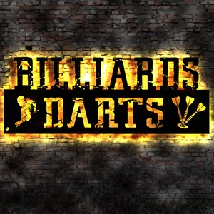 Op de afbeelding: Een geel neonbord met de woorden "Billiards & Darts" op een bakstenen muur. Het bord heeft een verweerde uitstraling en toont een silhouet van een persoon die biljart speelt en drie pijltjes.