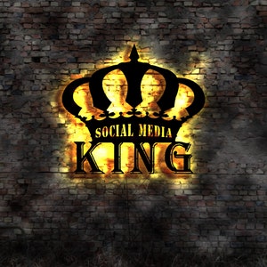 Può includere: Una silhouette nera di una corona con le parole "Social Media King" in una luce gialla su uno sfondo di muro di mattoni.