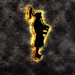 Puede incluir: Silueta de una persona tocando una gaita, iluminada por una luz amarilla brillante contra una pared de ladrillo oscuro.