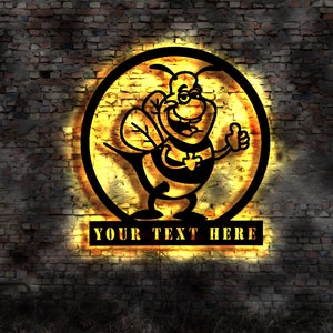 Peut inclure: Une abeille de dessin animé noire et jaune avec un visage amical et un pouce levé est à l'intérieur d'un cercle avec une lueur jaune. Le texte "YOUR TEXT HERE" est sous le cercle.