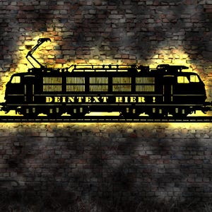 May include: A black silhouette of a train engine against a brick wall. The engine has the text "DEINTEXT HIER!" on the side.