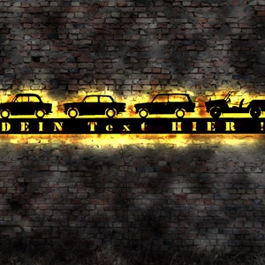 May include: Black metal silhouette of four cars and a jeep with the text "DEIN TEXT HIER!" on a brick wall background.