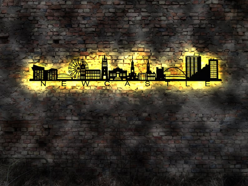 K&ouml;nnte beinhalten: Eine schwarze Silhouette der Skyline von Newcastle mit dem Wort "NEWCASTLE" in gelben Buchstaben darunter. Die Skyline umfasst Geb&auml;ude, eine Br&uuml;cke und ein Riesenrad.