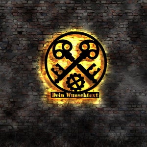 Puede incluir: Un letrero de metal negro con dos llaves cruzadas y un engranaje en el centro. El letrero está iluminado con una luz amarilla cálida y tiene el texto "Dein Wunschtext" debajo de las llaves.