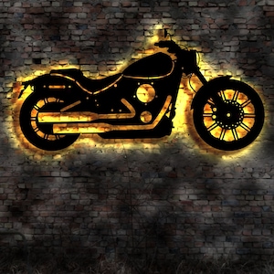 May include: A black motorcycle silhouette with a yellow glow behind it, on a brick wall background.