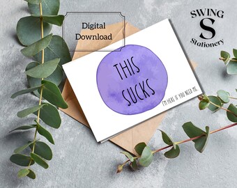 May include: A purple watercolor card with the text "This Sucks" and the message "I'm here if you need me." The card is on a brown envelope with the text "Swing Stationery" in the top right corner.