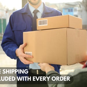 Puede incluir: Un repartidor con uniforme azul entrega dos cajas de cart&oacute;n marr&oacute;n a un cliente. Las cajas est&aacute;n apiladas una encima de la otra. El texto "ENV&Iacute;O GRATIS INCLUIDO EN CADA PEDIDO" es visible en la parte inferior de la imagen.