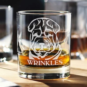 May include: A clear glass tumbler with a white etched image of a Shar-Pei dog with the text "Wrinkles" underneath. The glass is filled with amber liquid.