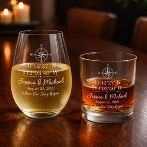 May include: Two clear glass tumblers, one stemless wine glass and one rocks glass, both etched with a compass rose, coordinates 36°12'27''N 112°03'40''W, the names Jessica & Michael, the date August 23, 2021, and the text Where Our Story Began.