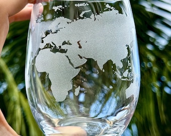 Könnte beinhalten: Ein klares Weinglas aus Glas mit einem gravierten Design der Weltkarte.