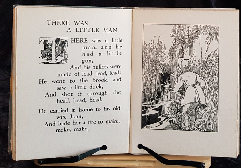 Op de afbeelding: Een open boek met illustraties en tekst. De linkerpagina heeft de titel "THERE WAS A LITTLE MAN" en een gedicht. De rechterpagina toont een man met een geweer in een moerassig gebied. De illustraties zijn in zwart-wit.