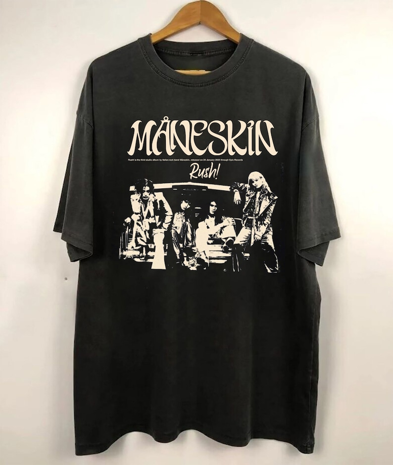 May include: Black t-shirt with a white graphic of the band M&aring;neskin. The graphic includes the band's name, the word "Rush!" and a silhouette of the band members.