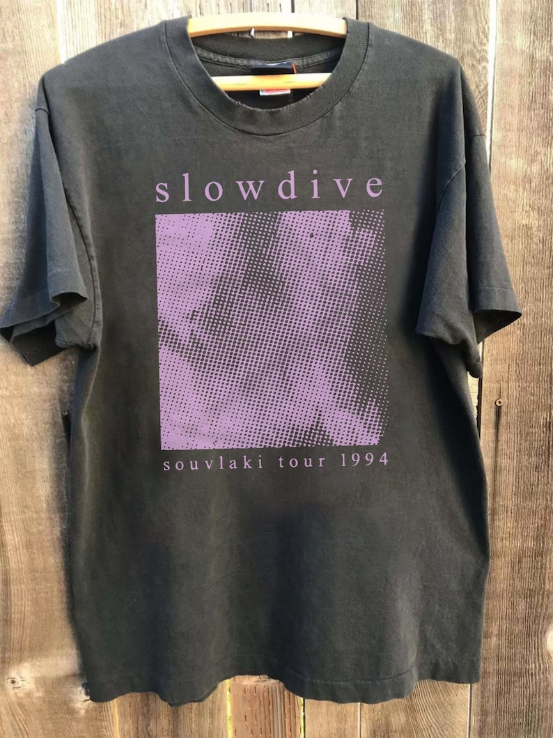 May include: Black t-shirt with a purple graphic of a pixelated design and the text "slowdive souvlaki tour 1994".