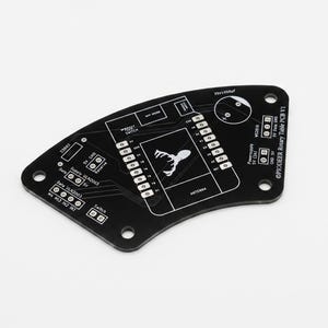 Może przedstawiać: Czarna płytka drukowana o zakrzywionym kształcie, z białymi nadrukami, centralnym logo głowy jelenia oraz napisem PIODEER Rotary Table PCB V1. Płytka posiada liczne otwory montażowe, złącza pinowe oraz oznaczenia dla komponentów elektronicznych.
